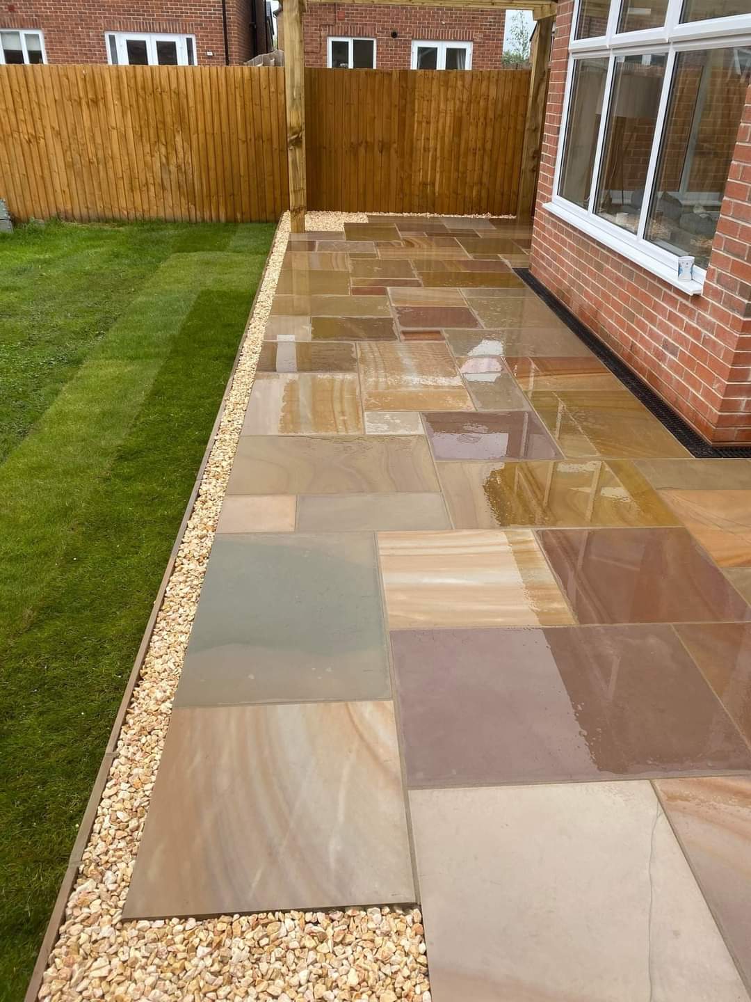 Camel Buff smooth sandstone paving laid in a garden setting