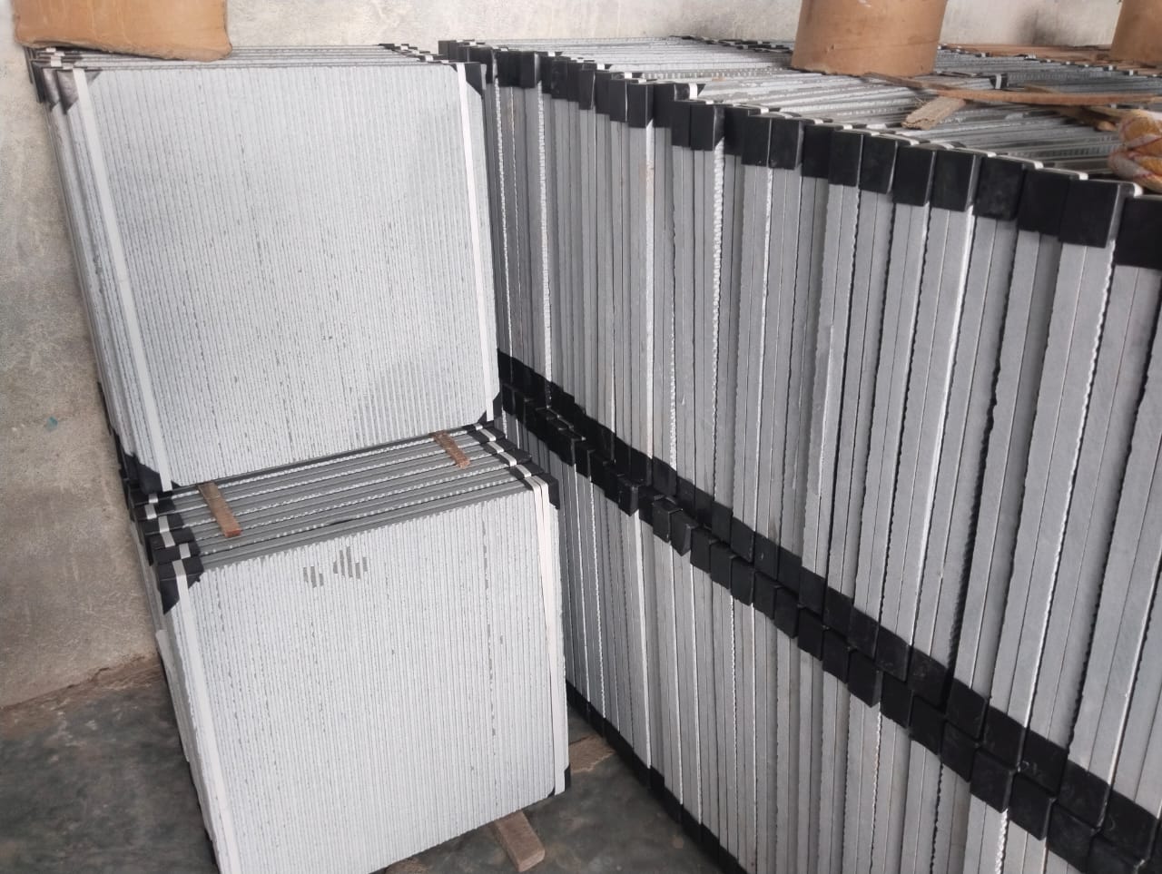 Polished Kota Stone tiles, back calibrated with plastic corner guards for transit