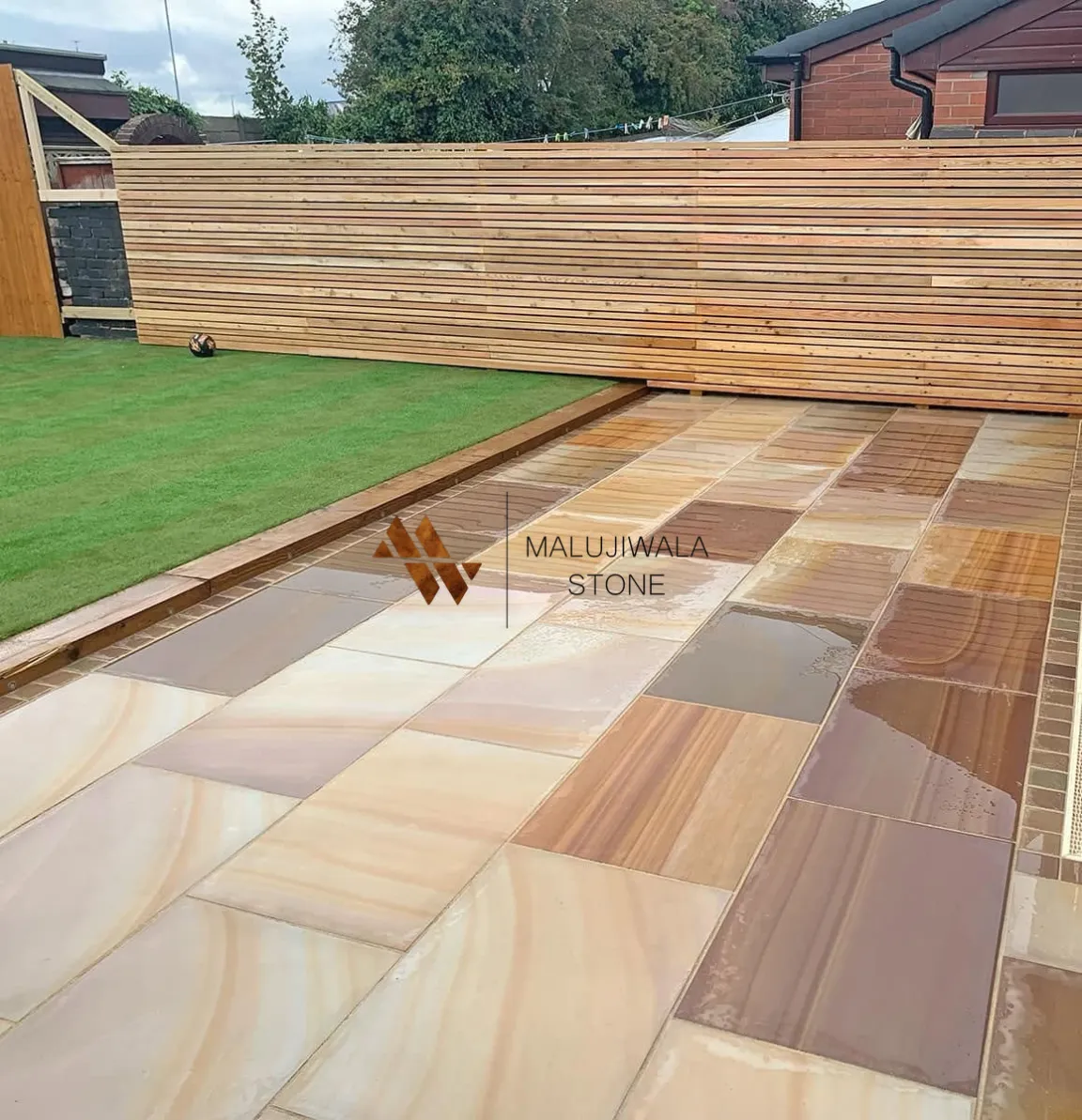 Smooth buff sandstone 600 x 900 paving laid across a patio
